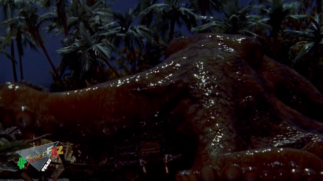 Screenshot aus dem Film Godzilla vs. King Kong. Zu sehen ist wie ein Riesenoktopus auf Land ein Dorf angreift.