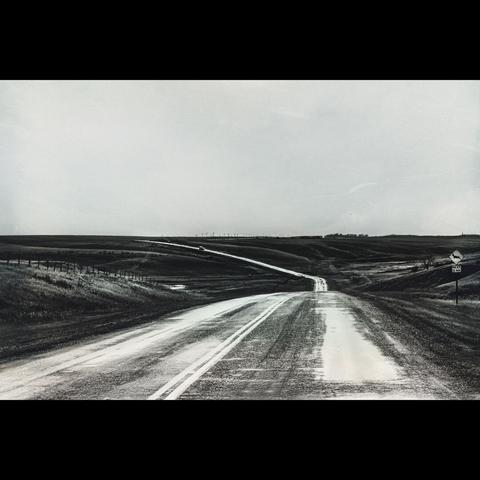 Blackand white photo, a long road in the plain of ALberta