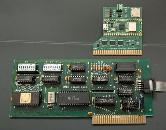 Two expansion cards for a vintage computer. At the top a very small green PCB with multiple small components and an edge connector at its bottom. Lower there is a much larger green PCBs with larger components.