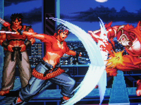 Rosa cross-slashes a red gas-mask-wearing ninja with her rad sword. In the background Sho Hayate looks suspiciously like a Dragon Ball Z character.