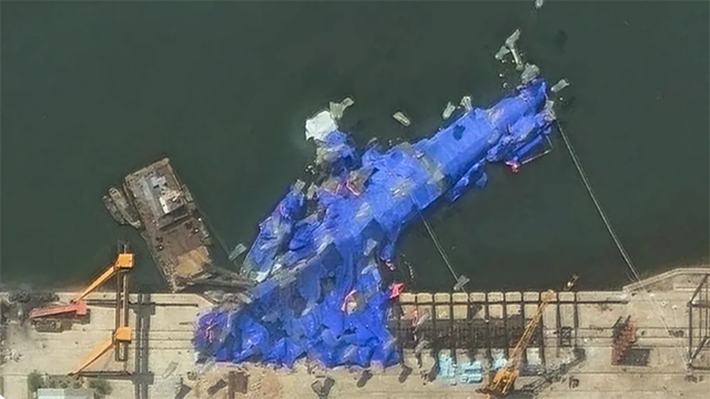 A ship covered with blue cloths to hide the evidence... but it's not working.