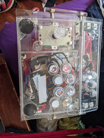 Top view photo of an arcade style Fight stick, made from clear acrylic save the wires, buttons, and PCB