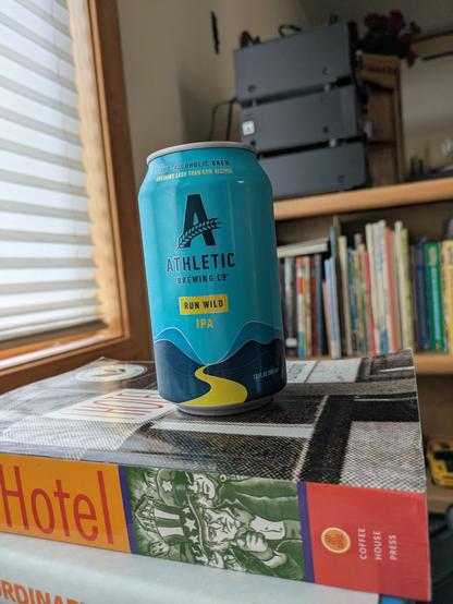 Can of Run Wild by Athletic Brewing company on a stack of books.
