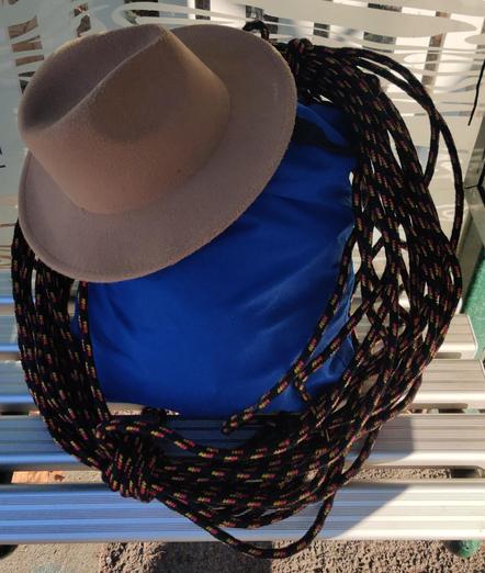 A bag with a coil of rope and an Indiana Jones styled hat.