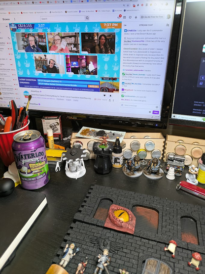The diorama pieces sitting on a desk. In a browser window, Desert Bus Express is playing in the background.