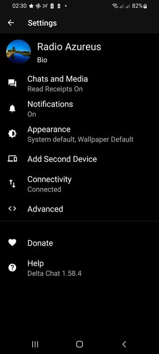 The image shows a smartphone screen displaying the settings menu of an application with avatar"Radio Azureus." The screen is predominantly black with white text and icons. At the top, there is a status bar showing the time as 02:30, a Wi-Fi signal, full battery at 82%, and a temperature of 24 degrees. Below the status bar, the word "Settings" is displayed in white text, with a left-pointing arrow icon.

The settings menu includes several options: "Chats and Media" with "Read Receipts On," "Notifications" turned on, "Appearance" set to "System default, Wallpaper Default," "Add Second Device," "Connectivity" with "Connected," and "Advanced." At the bottom of the screen, there are two additional options: "Donate" with a heart icon and "Help" with a question mark icon, indicating the version of the application as "Delta Chat 1.58.4." The profile picture next to the name "Radio Azureus" shows a scenic image of a blue sky and water.