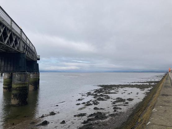 View of the Tay Firth with the rail bridge curving off to the left at low tide on a damp cloudy morning