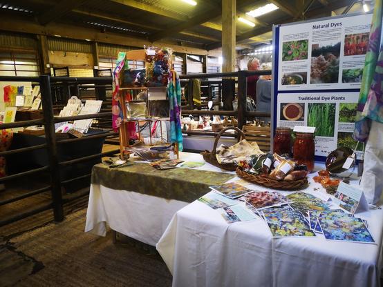 Inside Middleton-in-Teesdale Auction Mart, the pens are today the setting for a variety of makers and craftspeople to sell their wares. In this pen is 'Leaf and Thread' selling plant dyed fabrics, wool, silk and cards made from some of her designs.