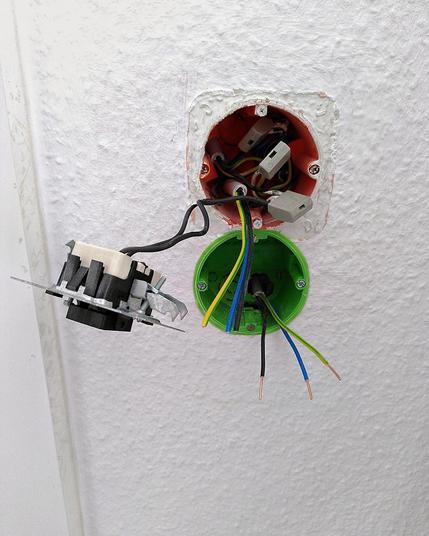 Steckdose unter Schalter nachgerüstet. Man sieht Drähte, Steckklemmen...