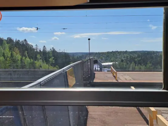 Photograph (colour): Railway station, in the background woods and a glimpse of the Baltic Sea