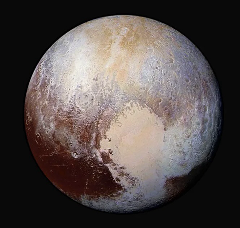 A NASA photo of Pluto, showing the distinctive heart shaped feature on its surface, surrounded by subtle merging hues of purple, brown and ochre.