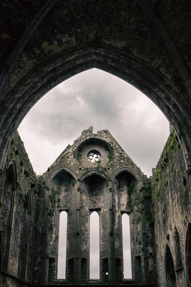 a shot taken from inside an old, partially ruined castle with a view of the sky
