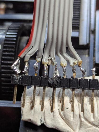Ribbon cable soldered to a 0.1 inch pin array. It's terrible. Everything is melted.