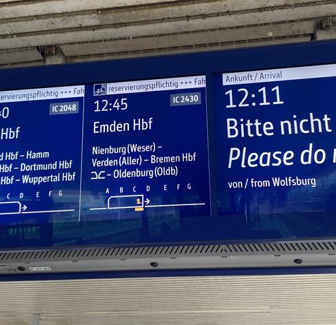 Ein Bild einer elektronischen Anzeigetafel am Bahnhof. Abgebildet der Zug nach Emden, ein IC Abfahrt um 12:45.