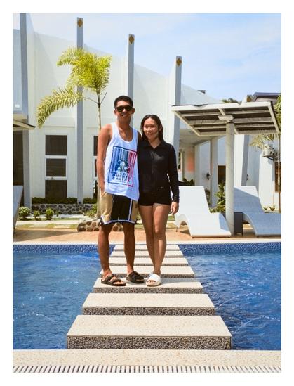 A couple taking a picture on stepping stones in a swimming pool.
