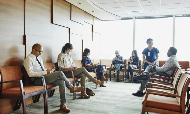 Varias personas en la sala de espera de un hospital. (Thomas M. Barwick INC / Getty)
