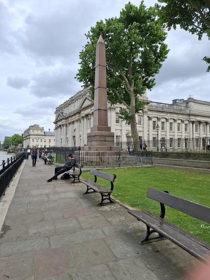 An obelisk in front of a grand building and lawns