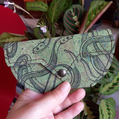 Pochette en tissu de liège vert imprimée et cousue à la main. Les motifs sont des serpents imprimés à répetition.