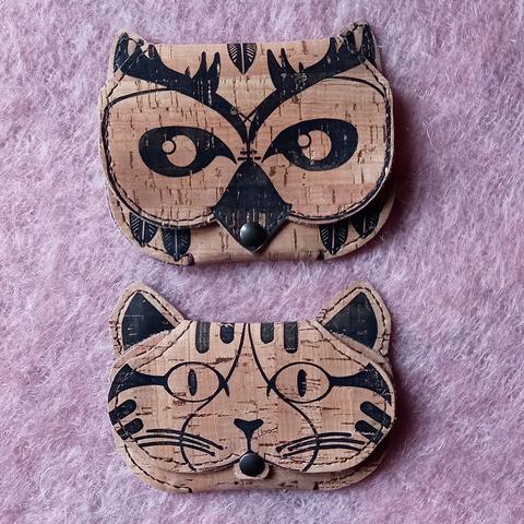 Deux pochettes en tissu de liège naturel imprimée et cousues à la main. Une des pochettes à la forme d'une tête de hibou grand duc, l'autre d'un chat.