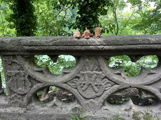 Die drei plüschigen Mammuts  auf einer Mauer mit Ornamenten