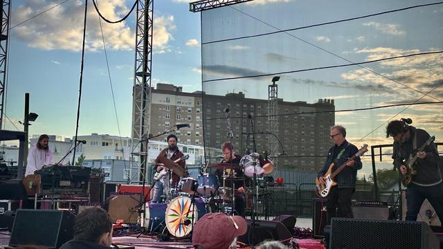 Joe Russo’s Almost Dead performing at the Stone Pony Summer Stage in Asbury Park NJ on Friday May 23, 2025. The band on stage while it was still daylight, a blue sky with illuminated clouds as the day approached sunset.