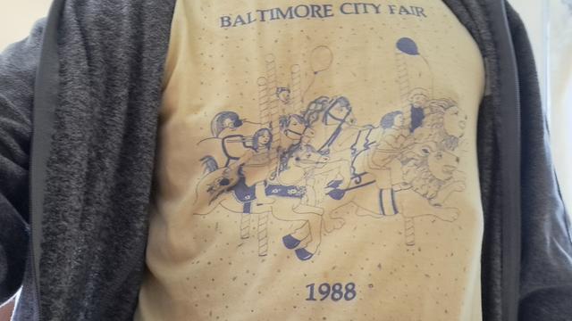 Yellow t shirt titled Baltimore City Fair 1988, with a cartoon ride.