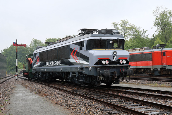 Photo of a locomotive with grey-black livery and red accents.