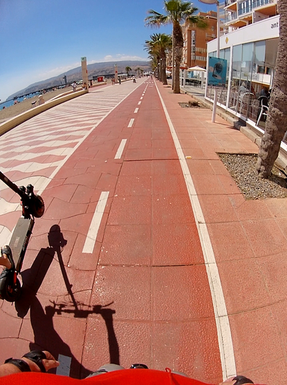 Scooter kid overtaking while doing a wheelie on the bike lane.