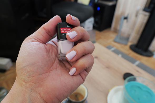 Hand hält ein Nagellackfläschen