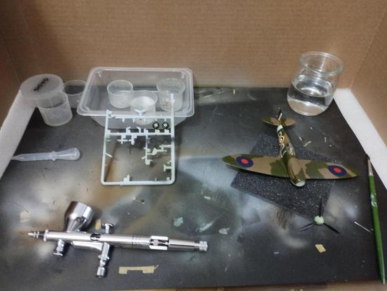 Maqueta de un Spitfire MkI y varias piezas sueltas recien barnizadas en brillo. Delante, el aerografo recien limpiado tras usarlo von el avión.