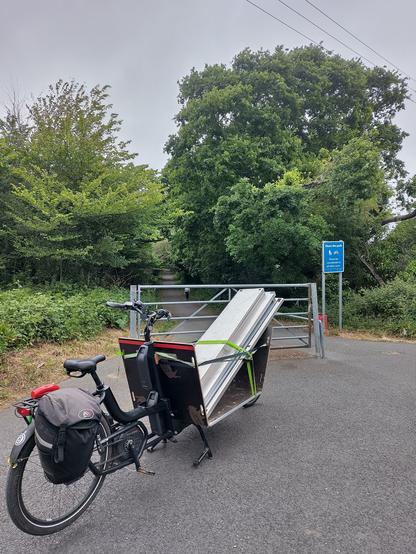 A large front loading cargo bike with a dismantled stainless table on the front