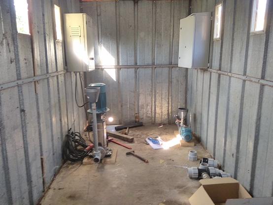 Intérieur de la cabane solaire, avec deux pompes et leur tableau électrique