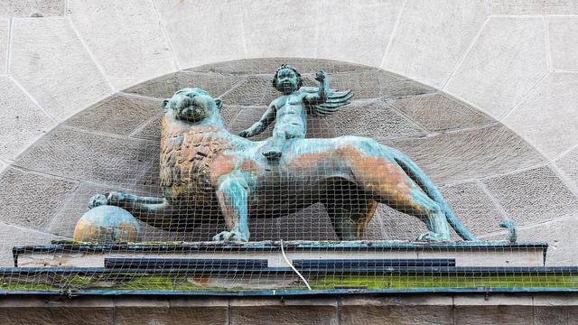 Junge, der auf einem Löwe sitzt. Bronzefigur
