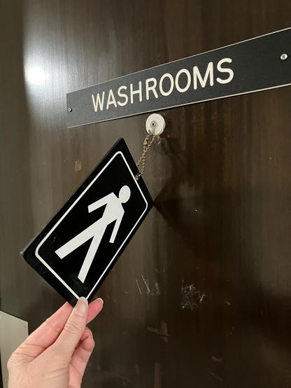 A washroom with a sign that can be flipped, f t m