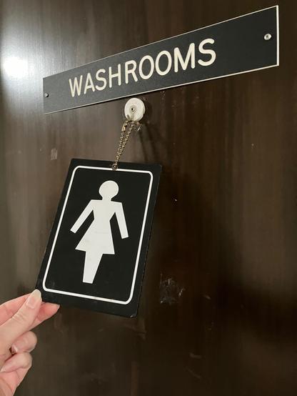 A washroom with a sign that can be flipped, f t m