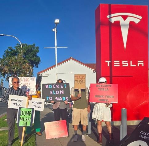 Protesters hold signs near a Tesla store, encouraging a boycott of the company with messages like "Rocket Elon to Mars" and "Dump Musk!" image by ‪San Gabriel Valley Tesla Protests‬  ‪@sgvteslaprotests.bsky.social‬