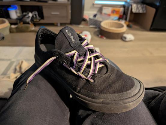 My right shoe, which is black, facing the camera as if in an apparel catalog. It's laced with one of the new shoelaces in a visually appealing pattern where the lace doubles back along the sides of the shoe.