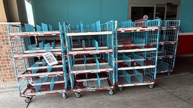 Several of the vertical carts that grocery store staff use for shopping for curbside pickup and delivery orders. This was taken at an H-E-B near me.