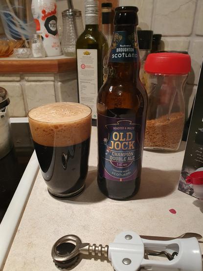 Nästan svart öl i glas. Brun skumkrona.
