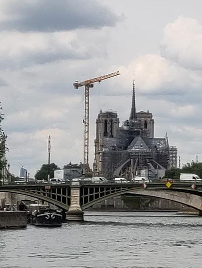 notre dame de paris vor bewölktem himmel

daneben steht ein kran