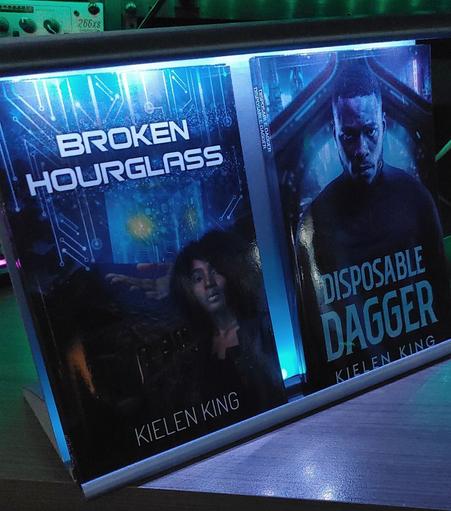 Completed 3D printed custom bookstand with two books inserted for reference and LED lights add to the top and bottom for effect.
