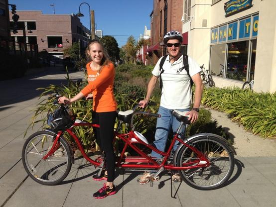 Two visitors from Australia stand alongside a tandem bike they rented on Cannery Row in Monterey.