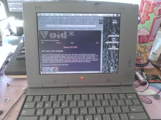 An old 90s powerbook duo with netscape on the screen with my website, voidptr.org, loaded