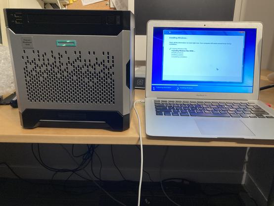 The HP Enterprise Microserver is a cube-like box of silver. It sits alongside a 2014 Macbook Air, and is approximately the same volume.