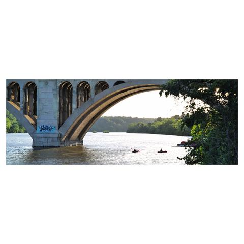 Landscape portrait of the Potomac river at sunset with two canoes in the water under the bridge