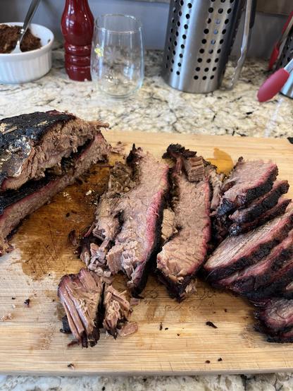 Slices of beef brisket on a wooden cutting board.