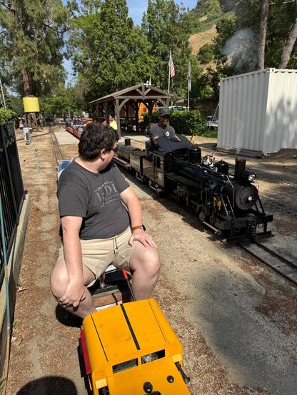 Me behind the cab of a small diesel locomotive watching a large Shay steam train pass me by
