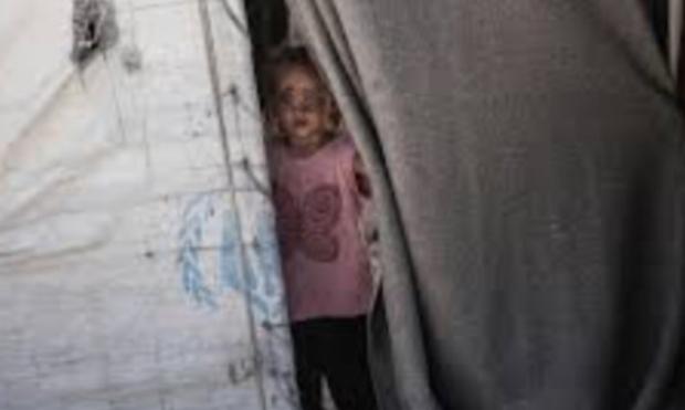 Un enfant à l’entrée d’une tente de l’ONU.