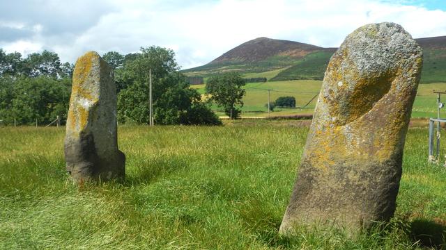 Two large, 1.95 metre high, standing stones. The skyline view between the stones is a clearly defined hill.