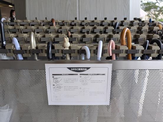 A huge umbrella stand outside of a museum. Each umbrella goes into a holder that can be individually locked.